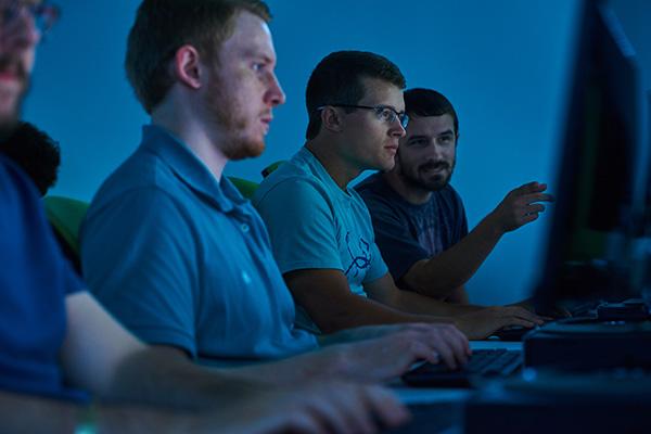 三个计算机工程专业的学生在一间计算机实验室里工作